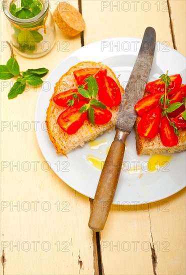 Italian tomato bruschetta with thyme and mint leaves