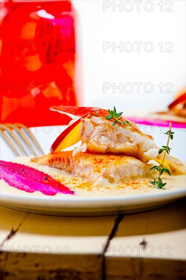 Sea bream orata fillet butter pan fried with fresh peach prune and dragonfruit slices thyme on top