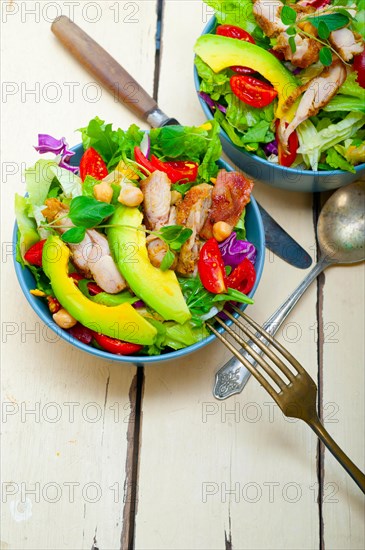 Fresh and healthy Chicken Avocado salad over rustic wood table