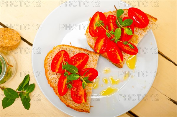 Italian tomato bruschetta with thyme and mint leaves