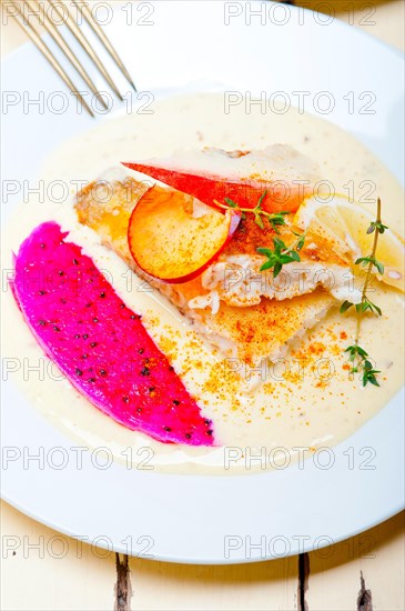 Sea bream orata fillet butter pan fried with fresh peach prune and dragonfruit slices thyme on top