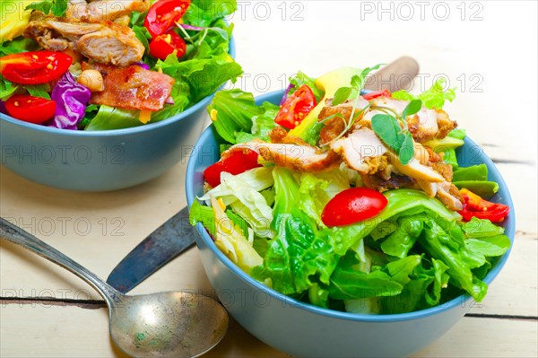 Fresh and healthy Chicken Avocado salad over rustic wood table