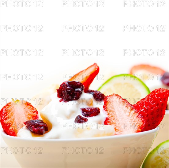 Fruit and yogurt salad healthy breakfast over white wood table