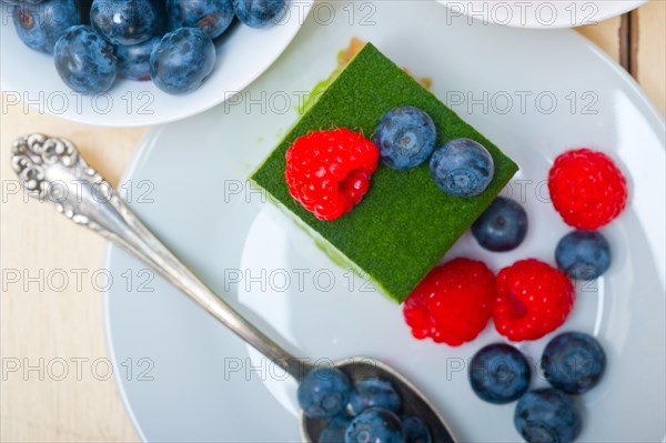 Green tea matcha mousse cake with raspberries and blueberries on top