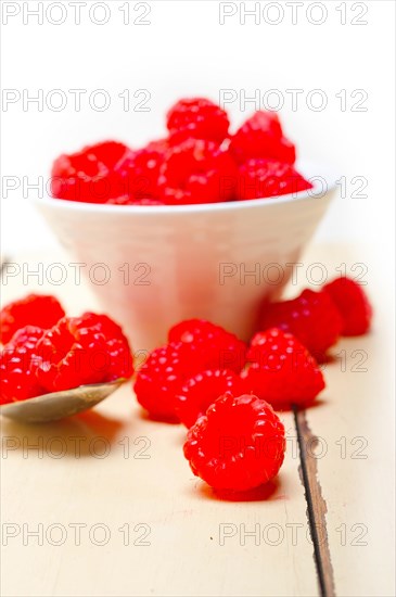 Bunch of fresh raspberry on a bowl and white wood rustic table