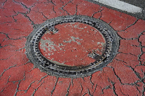 Manhole cover in cracked asphalt