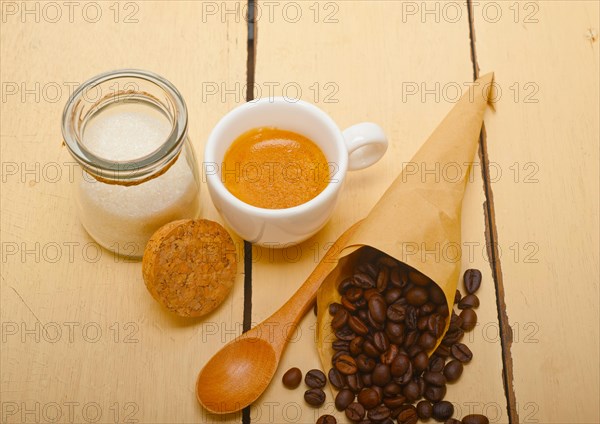 Espresso coffee and beans on a paper cone cornucopia over white background