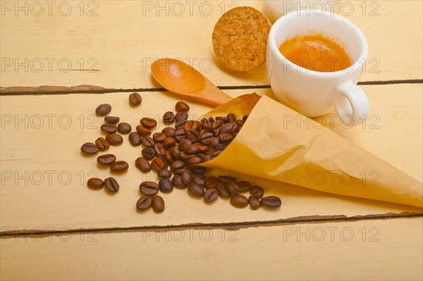 Espresso coffee and beans on a paper cone cornucopia over white background