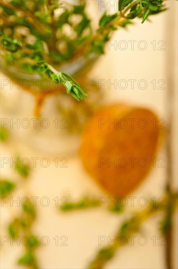 Fresh thyme on a glass jar over a white wood rustic table