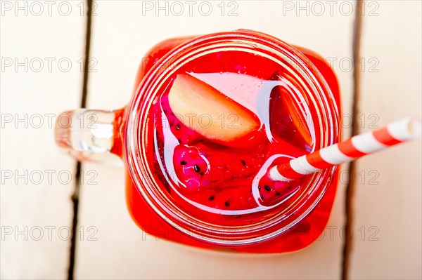 Fresh fruit punch refreshing summer drink over white rustic wood table