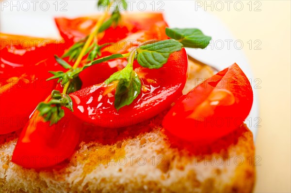 Italian tomato bruschetta with thyme and mint leaves