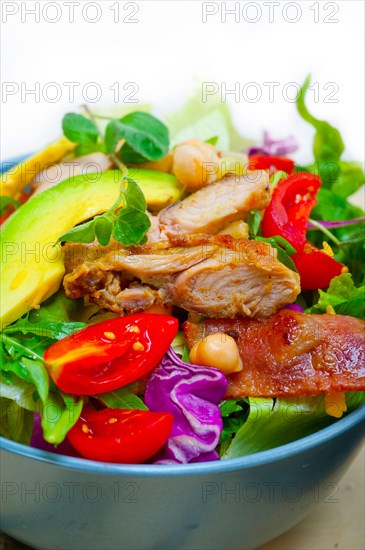 Fresh and healthy Chicken Avocado salad over rustic wood table