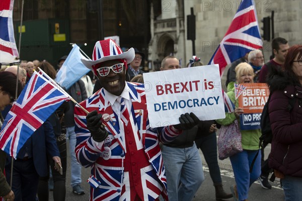 Man with Brexit is Democracy sign and wearing UK suit at a Leave means Leave march
