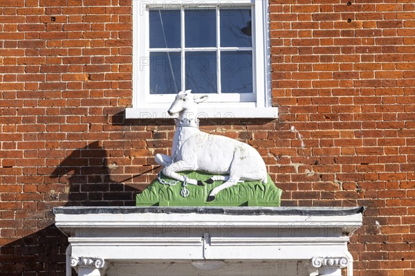 Historic sculpture of white hart deer above former entrance door to hotel