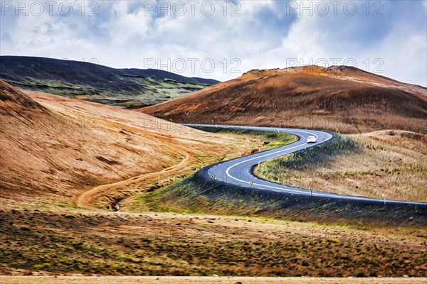 Winding asphalt road through hilly landscape