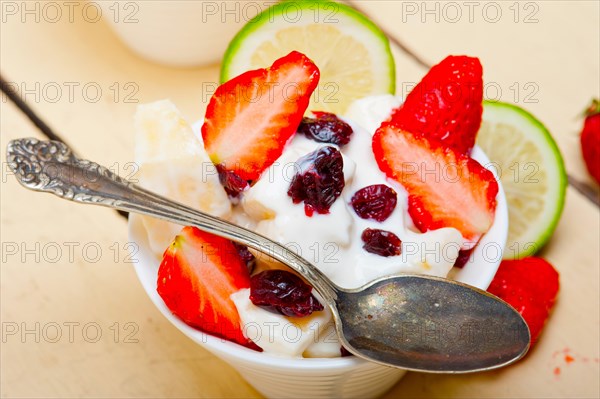 Fruit and yogurt salad healthy breakfast over white wood table