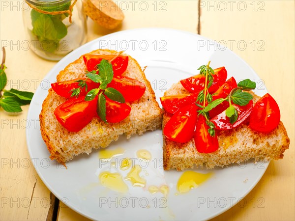 Italian tomato bruschetta with thyme and mint leaves