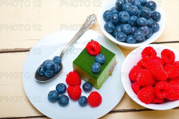 Green tea matcha mousse cake with raspberries and blueberries on top