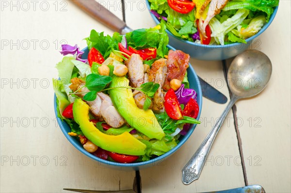 Fresh and healthy Chicken Avocado salad over rustic wood table