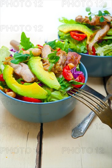 Fresh and healthy Chicken Avocado salad over rustic wood table