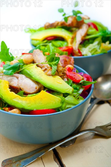 Fresh and healthy Chicken Avocado salad over rustic wood table