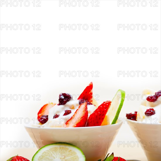 Fruit and yogurt salad healthy breakfast over white wood table