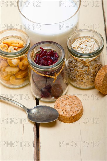 Healthy breakfast ingredients milk oat cashew nuts dried cramberry craisinns