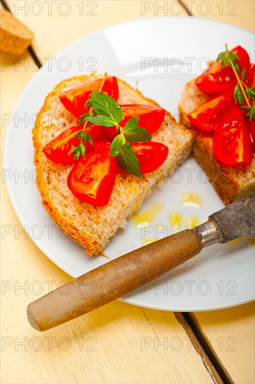 Italian tomato bruschetta with thyme and mint leaves