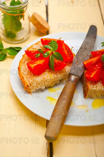 Italian tomato bruschetta with thyme and mint leaves