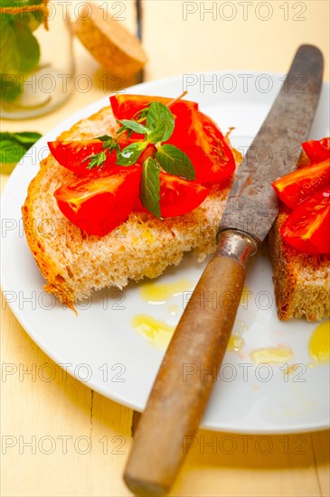 Italian tomato bruschetta with thyme and mint leaves