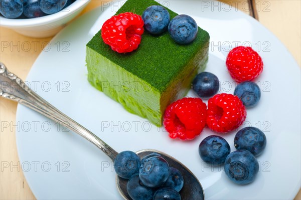 Green tea matcha mousse cake with raspberries and blueberries on top