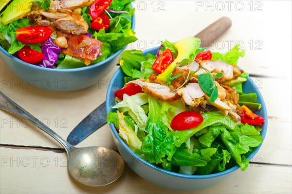 Fresh and healthy Chicken Avocado salad over rustic wood table