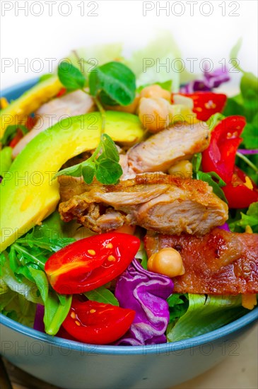 Fresh and healthy Chicken Avocado salad over rustic wood table