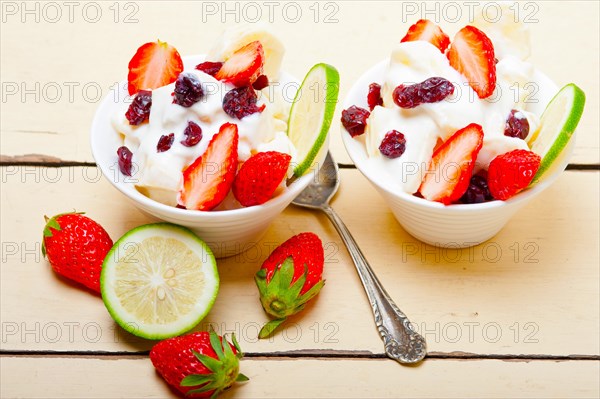 Fruit and yogurt salad healthy breakfast over white wood table