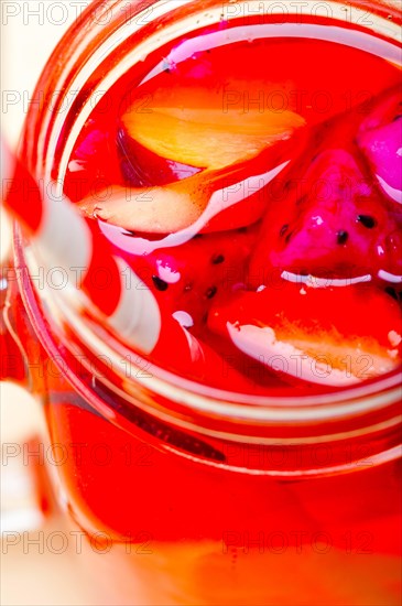 Fresh fruit punch refreshing summer drink over white rustic wood table