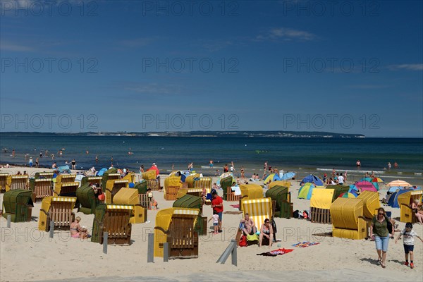 Beach chairs with holidaymakers on the beach and Baltic Sea