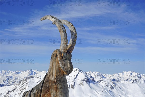 Wooden ibex figure, work of art, snow-capped mountains, La Masse peak, Trois 3 Vallees ski resort, Les Menuires, Haute Savoie, High Savoie, France, Europe