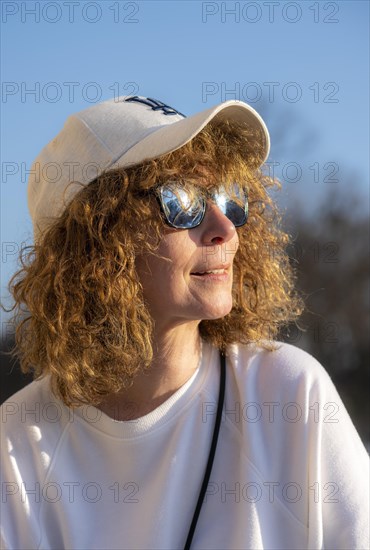 Woman with curly hair enjoying the evening sun
