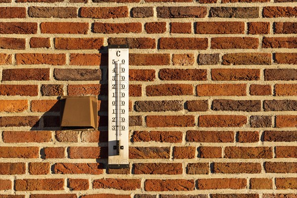 Thermometer on a red brick wall