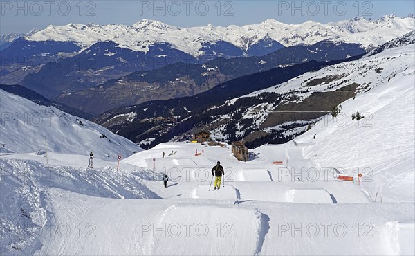 Skier jumps over ski jump in fun park