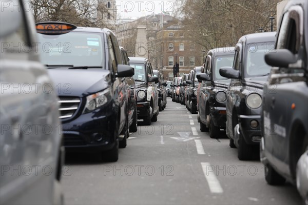 Black London taxis parked on road at the Palace of Westminster during a protest