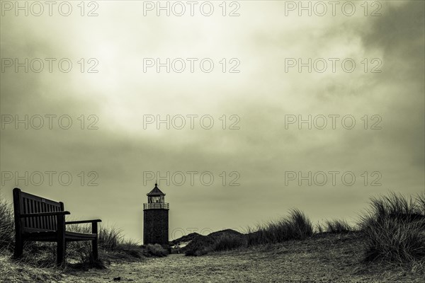 Red cliff cross light with wooden bench