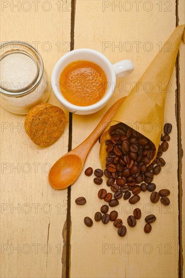 Espresso coffee and beans on a paper cone cornucopia over white background