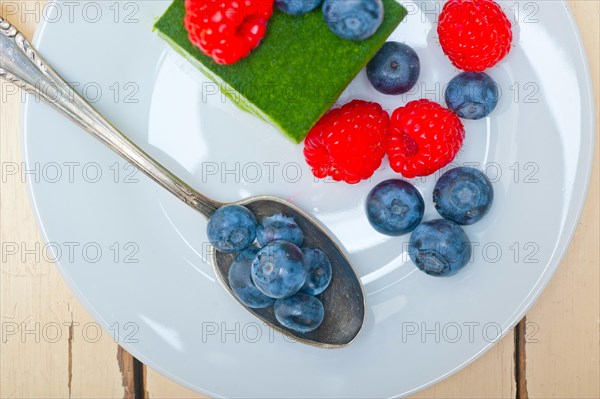 Green tea matcha mousse cake with raspberries and blueberries on top