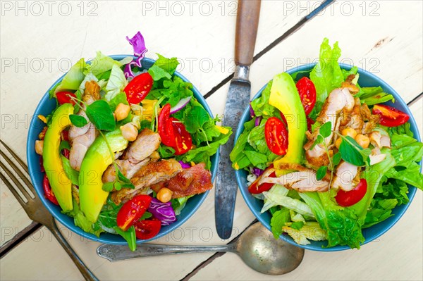 Fresh and healthy Chicken Avocado salad over rustic wood table