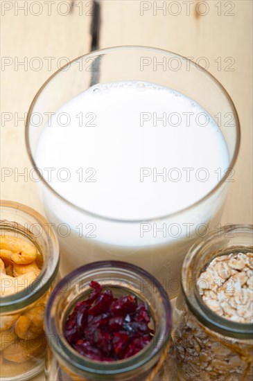 Healthy breakfast ingredients milk oat cashew nuts dried cramberry craisinns