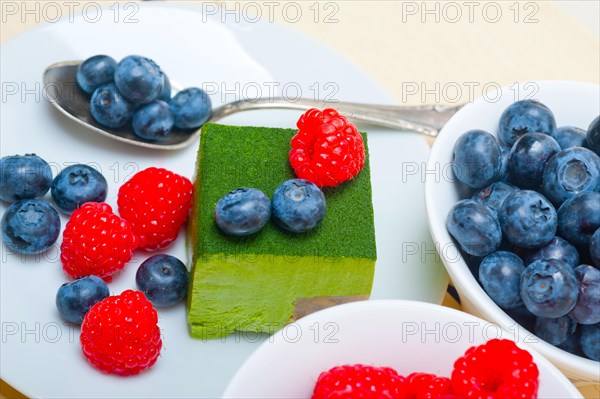 Green tea matcha mousse cake with raspberries and blueberries on top