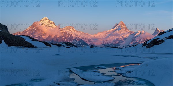 Evening light on the Bernese Alps with frozen Bachsee lake in the foreground