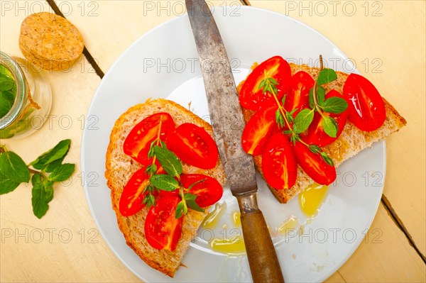 Italian tomato bruschetta with thyme and mint leaves