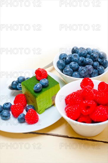 Green tea matcha mousse cake with raspberries and blueberries on top